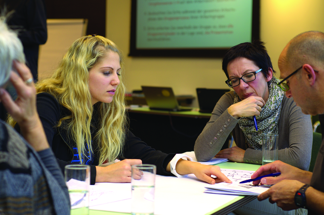 Sales training conversation at a meeting table